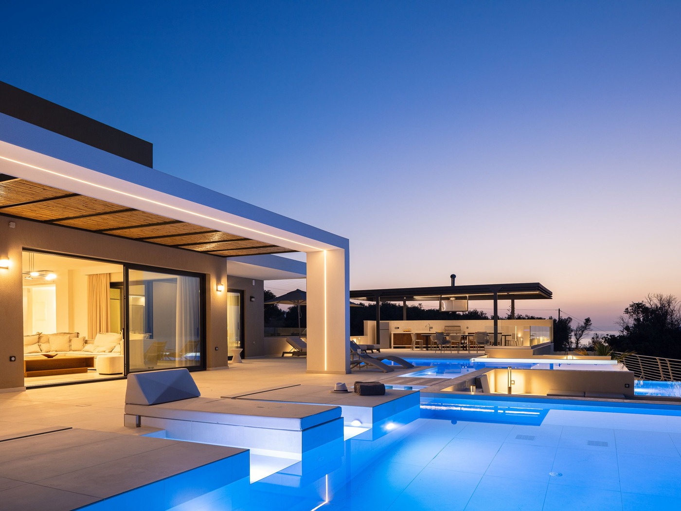 Villa auf Kreta in der Abenddämmerung mit beleuchtetem Pool